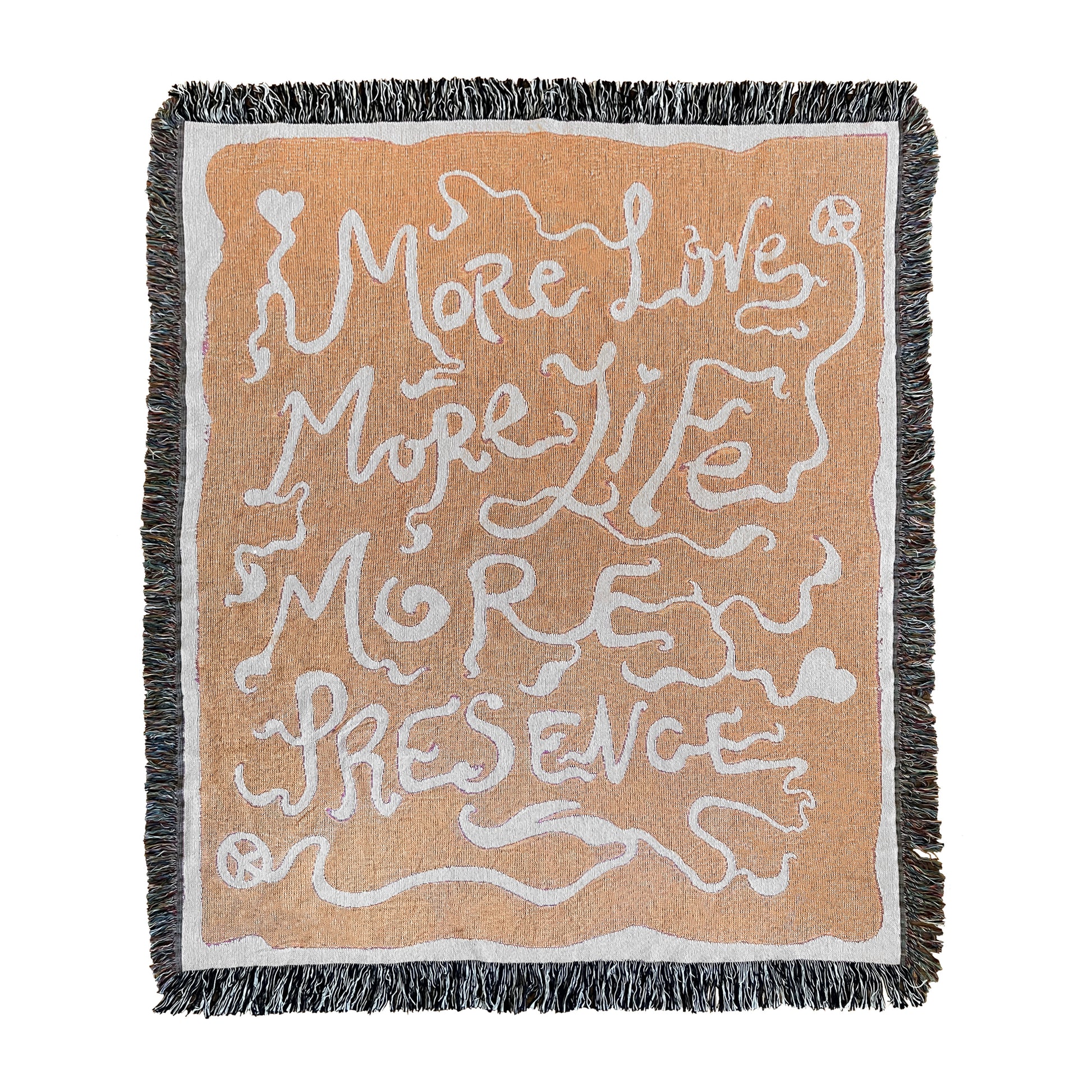 A rectangular woven blanket with a text pattern that reads 'MORE LOVE MORE LIFE MORE PRESENCE' on an orange background, with a grey fringe border.